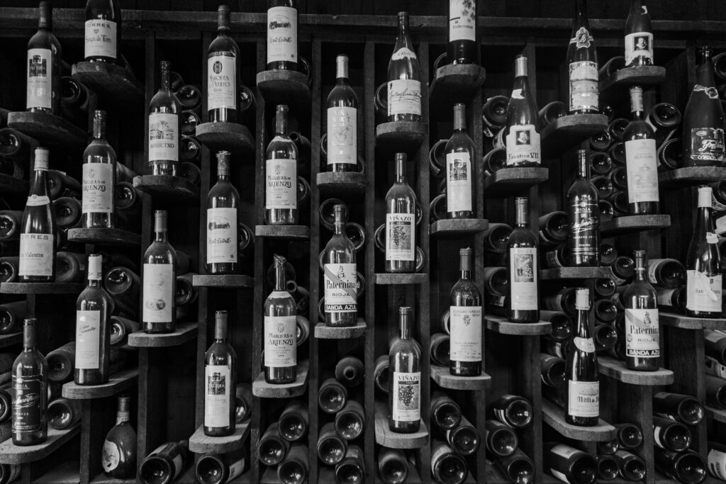 A black and white photo showcasing an elegant wine rack filled with various bottles.